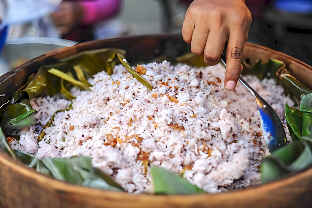 A traditional xoi is served in a wooden container lined with banana leaves